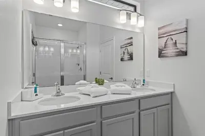 a bathroom with two sinks and a large mirror at Unforgettable Vacation: 9BR Paradiso Grand Resort in Orlando