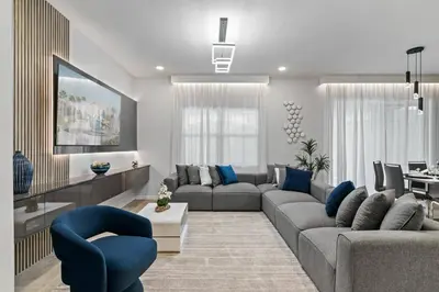 a living room with a gray couch and blue chairs at Paradiso Grand Resort 6 bedroom in Orlando