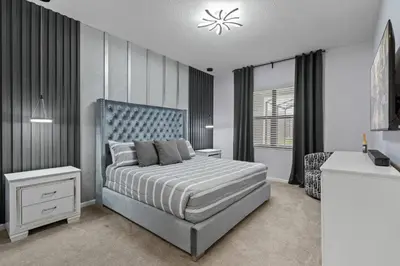 a bedroom with a bed with a blue headboard at Paradiso Grand Resort 6 bedroom in Orlando