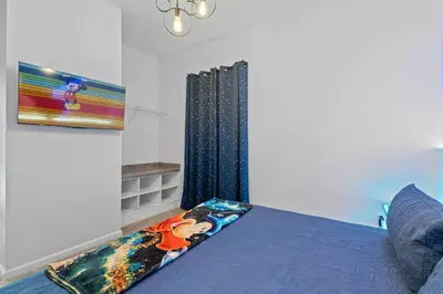 a bedroom with a blue bed and a window at Luxury Living: 6BR Condo near SeaWorld ICON Park in Orlando