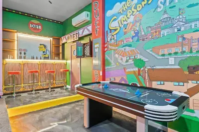a room with a ping pong table and a mural at Luxury Living: 6BR Condo near SeaWorld ICON Park in Orlando