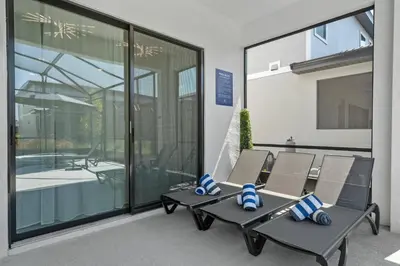 a patio with a table and chairs in front of a building at Luxury Living: 6BR Condo near SeaWorld ICON Park in Orlando