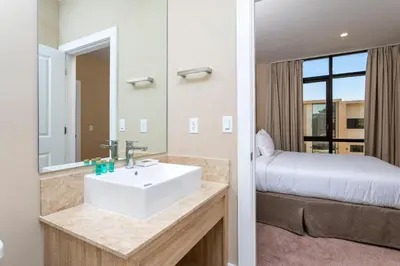 a bathroom with a sink and a bed in a room at Casa 3Q c/ Área de Churrasco – Próx. Disney in Orlando