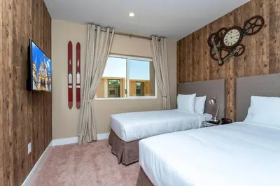 a hotel room with two beds and a clock on the wall at Casa 3Q c/ Área de Churrasco – Próx. Disney in Orlando