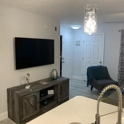 a living room with a flat screen tv on a wall at Villa del Sol in Kissimmee