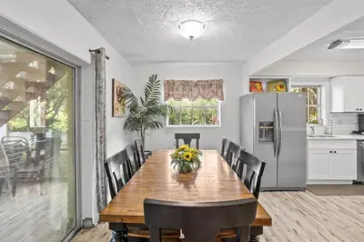 a dining room with a table and a refrigerator at 4 Rooms, Lake, Pool, Hot Tub, Putt-Putt in Orlando