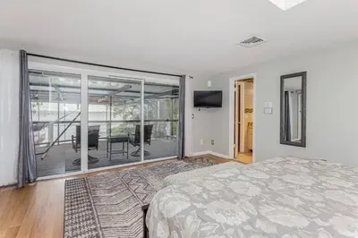 a bedroom with a bed and a view of a balcony at 4 Rooms, Lake, Pool, Hot Tub, Putt-Putt in Orlando