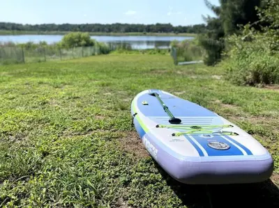 a kayak sitting on the grass next to a lake at 6 Bedroom Historic Home in Orlando