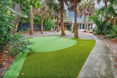 a golf course in front of a house with palm trees at 6 Bedroom Historic Home in Orlando
