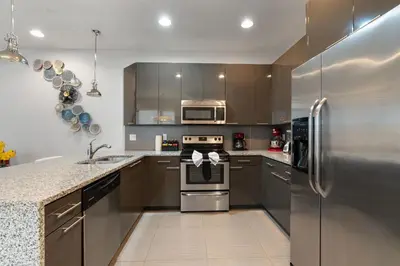 a kitchen with a stainless steel refrigerator and a sink at Casa 3Q c/ Piscina Privativa – Refúgio Familiar in Orlando