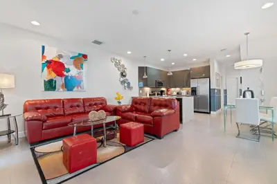 a living room with red furniture and a kitchen at Casa 3Q c/ Piscina Privativa – Refúgio Familiar in Orlando