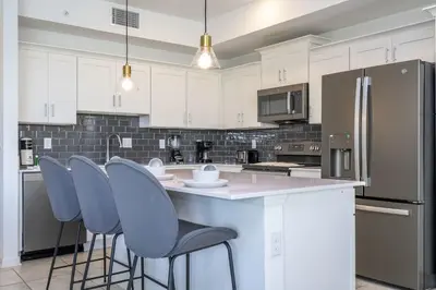 a kitchen with white cabinets and blue bar stools at Storey Lake Resort 1250 - Hosted by Top Villas in Kissimmee
