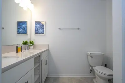 a white bathroom with a toilet and a sink at Storey Lake Resort 1250 - Hosted by Top Villas in Kissimmee