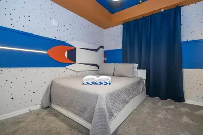 a bedroom with a bed with blue and orange walls at Storey Lake Resort 1250 - Hosted by Top Villas in Kissimmee