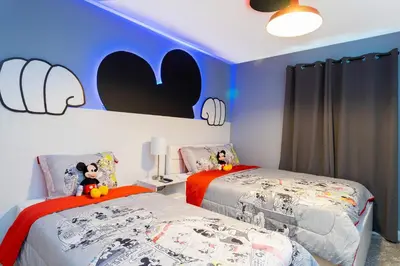 two twin beds in a room with blue walls at Storey Lake Resort 363 - Hosted by Top Villas in Kissimmee