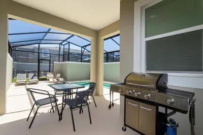 a patio with a grill and a table and chairs at Storey Lake Resort 363 - Hosted by Top Villas in Kissimmee