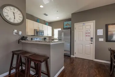 a kitchen with a counter and a clock on the wall at Corner Villa in West Lucaya – Your Ideal Getaway in Kissimmee