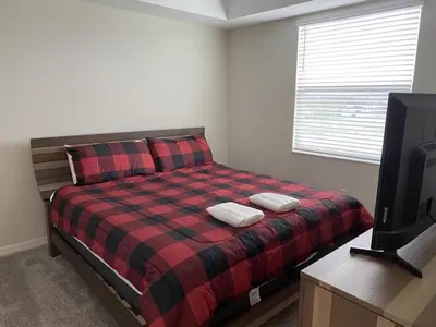 a bedroom with a bed with two pillows and a tv at Comfortable 2BR Condo w/ Lake Views in Kissimmee