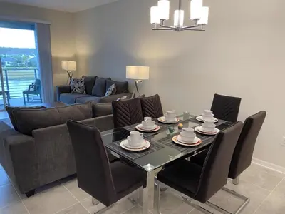 a living room with a table and chairs and a couch at Comfortable 2BR Condo w/ Lake Views in Kissimmee