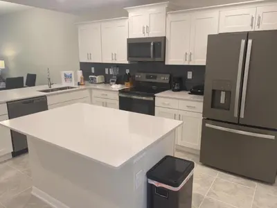 a kitchen with white cabinets and a white counter top at Comfortable 2BR Condo w/ Lake Views in Kissimmee