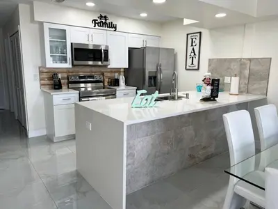 a kitchen with white cabinets and a counter top at Grand Luxury 3BR Penthouse near Disney Parks in Kissimmee