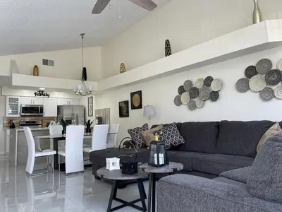 a living room and kitchen with a couch and a table at Grand Luxury 3BR Penthouse near Disney Parks in Kissimmee