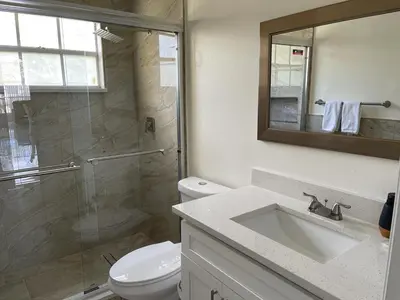 a bathroom with a toilet and a sink and a shower at Grand Luxury 3BR Penthouse near Disney Parks in Kissimmee