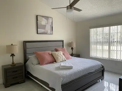 a bedroom with a bed with pink pillows on it at Grand Luxury 3BR Penthouse near Disney Parks in Kissimmee