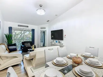 a white living room with a table and chairs at The Galactic Getaway, 3Bed, 2Bath Apartment, Free Parking, Heated Pool in Kissimmee