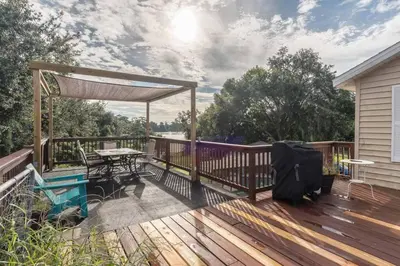 a wooden deck with a picnic table and a pergola at Large Deck, Lakefront, Yard Games in Orlando