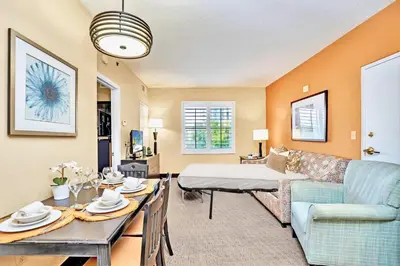 a living room with a couch and a table at Condo with Pool & Hot Tub - Universal Studios in Orlando