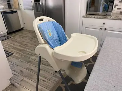 a white high chair with a blue seat in a kitchen at 4 Rooms, Lake, Pool, Hot Tub, Bocce Ball, Putting in Orlando