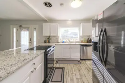 a kitchen with white cabinets and black appliances at 4 Rooms, Lake, Pool, Hot Tub, Bocce Ball, Putting in Orlando