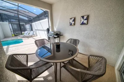 a table and chairs in a room with a pool at Beautiful Storey Lake Retreat Minutes from Disney in Kissimmee