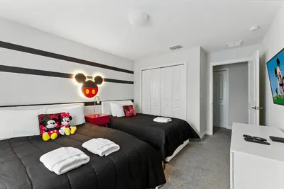 a bedroom with two beds with black sheets at Beautiful Storey Lake Retreat Minutes from Disney in Kissimmee