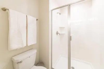 a bathroom with a toilet and a glass shower at Beautiful Storey Lake Retreat Minutes from Disney in Kissimmee