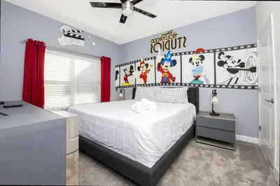 a bedroom with a large white bed with a wall of cartoons at Stunning 4Bd Close to Disney with Pool at Storey Lake 4369 in Kissimmee