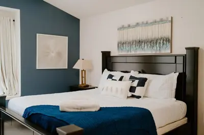 a bedroom with a large bed with blue walls at Luxury Private Pool Villa near Disney with Fire Pit, Game Room & More in Kissimmee