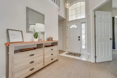 a room with a dresser with a mirror and a door at 15 Mi to Universal Home with Pool in Kissimmee
