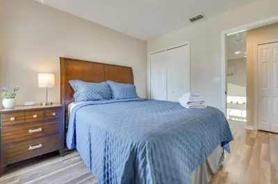 a bedroom with a bed and a dresser with a blue bedspread at 15 Mi to Universal Home with Pool in Kissimmee
