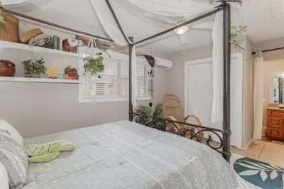 a bedroom with a bed with a canopy at Lakefront Guest House By Downtown, Boat, Fishing in Orlando