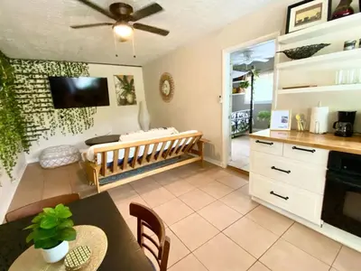 a living room with a dining table and a tv at Lakefront Guest House By Downtown, Boat, Fishing in Orlando