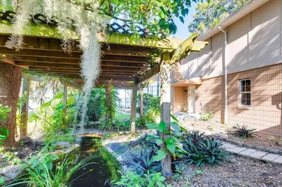 a garden with a pond in front of a building at Lakefront Guest House By Downtown, Boat, Fishing in Orlando
