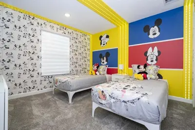 a bedroom with two beds and a wall with mickey characters at Storey Lake 4Q/3B acesso Resort e Piscina Priv. in Kissimmee