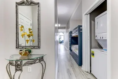 a hallway with a glass table and a mirror at Disney Lakefront Luxury! in Orlando