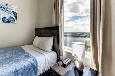 a bedroom with a bed and a large window at Disney Lakefront Luxury! in Orlando