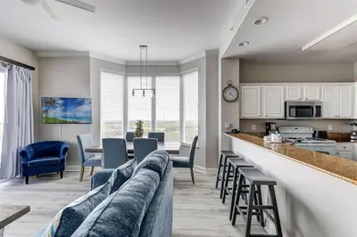 a kitchen and living room with a couch and chairs at Disney Lakefront Luxury! in Orlando