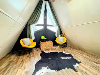 a room with two chairs and a broken floor at Hook's Cabin- Lake & Pool Near Disney A-frame in Clermont