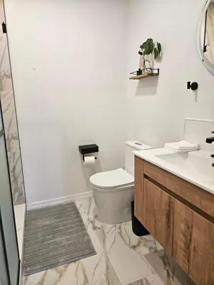 a bathroom with a toilet and a sink and a shower at Newly Renovated Modern Studio in Oviedo