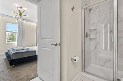 a bathroom with a shower with a glass door at 4561 Majestic 9BD Kingdom Retreat Near Disney in Kissimmee